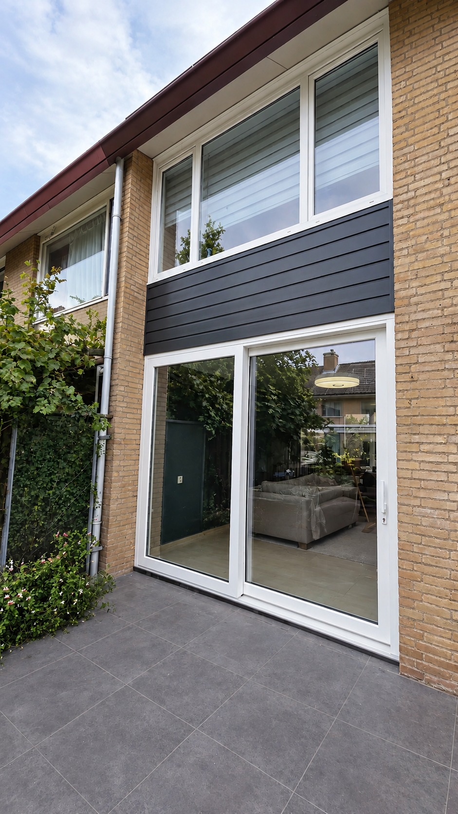 Witte kunststof schuifpui en kozijnen met antraciet rabat gevelbekleding bij woning